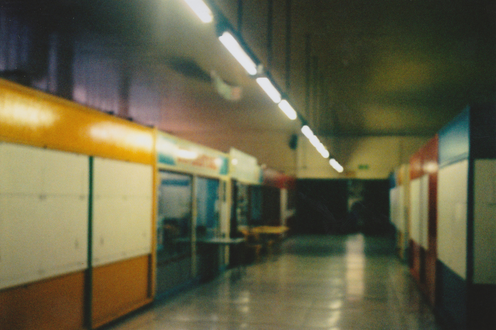 A dimly lit indoor market looking empty and run down