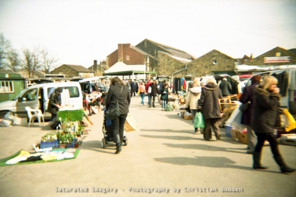 A film photo of people at a car boot sale