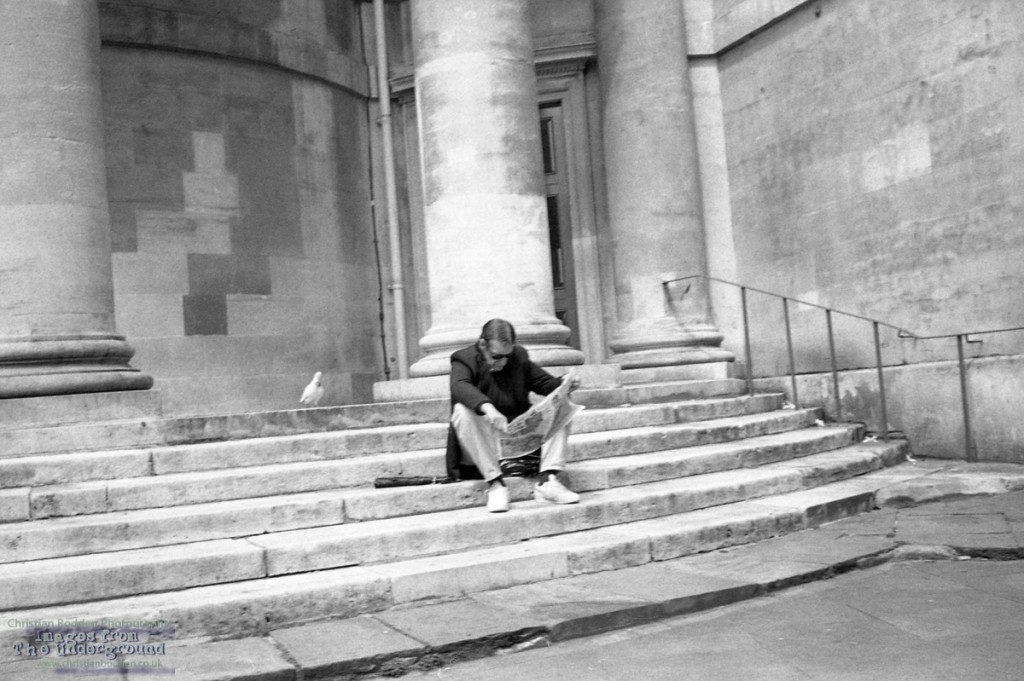 man on steps reading paper
