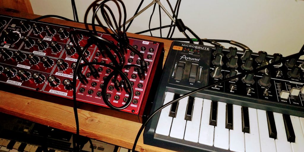 Two analogue synthesisers connected with patch cables