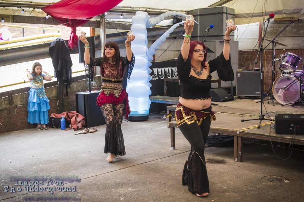 Two women belly-dancing in a marquee