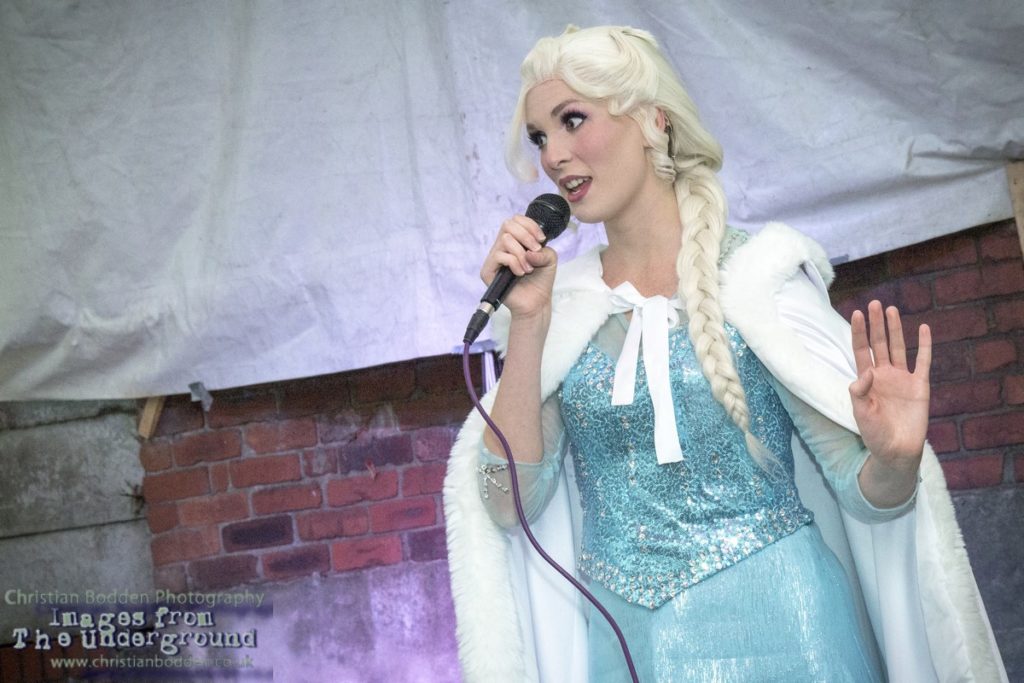 A woman singing dressed as the Character Elsa from the film Frozen
