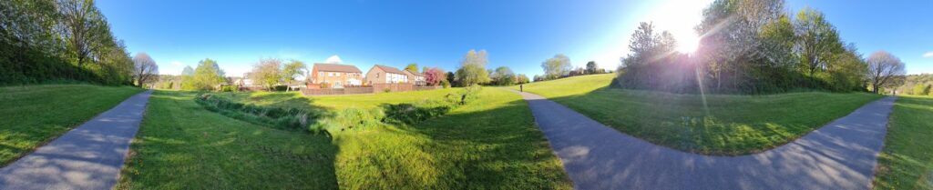 A Panorama image of a path through a small park