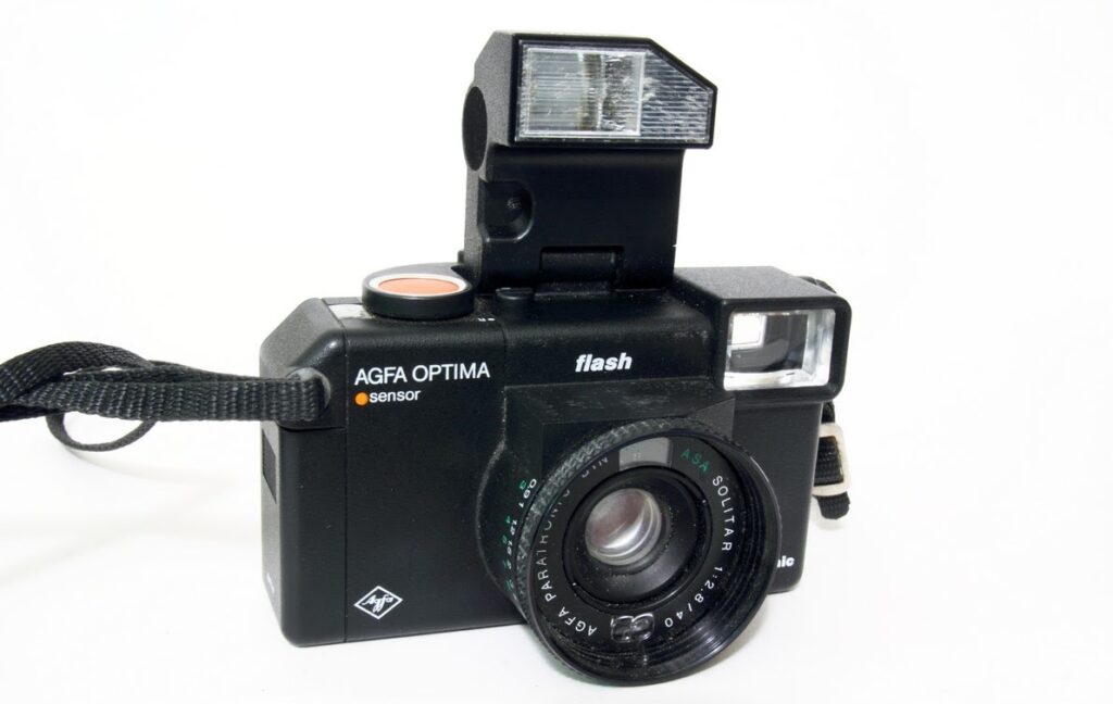 A black camera with a raised flash